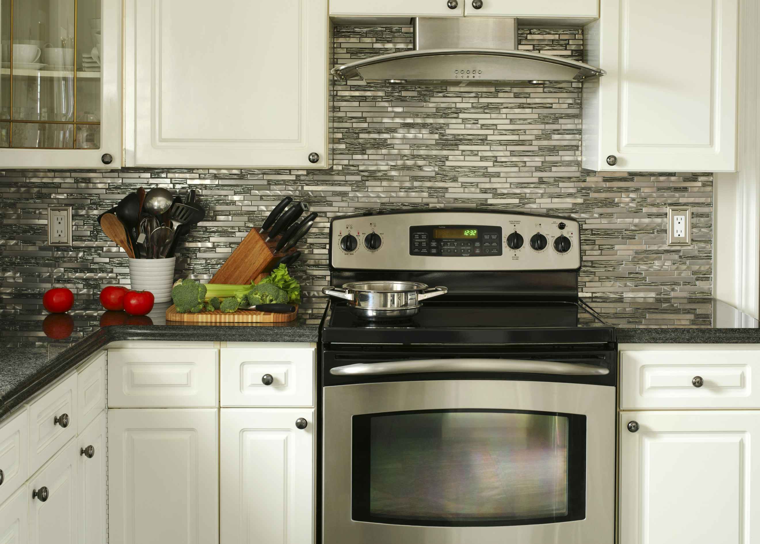 An electric stove with four burners positioned in the middle of the kitchen.