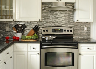 An electric stove with four burners positioned in the middle of the kitchen.