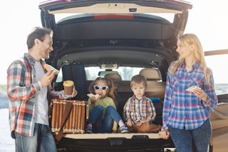 Family taking a driving break and having a snack