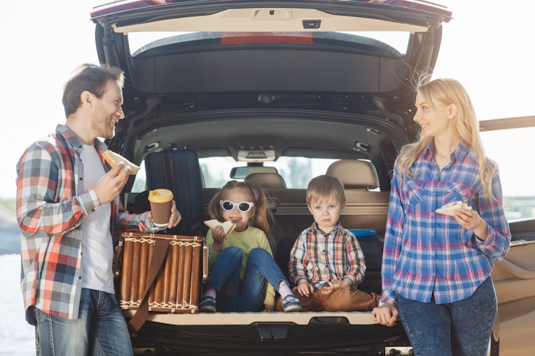 Family taking a driving break and having a snack