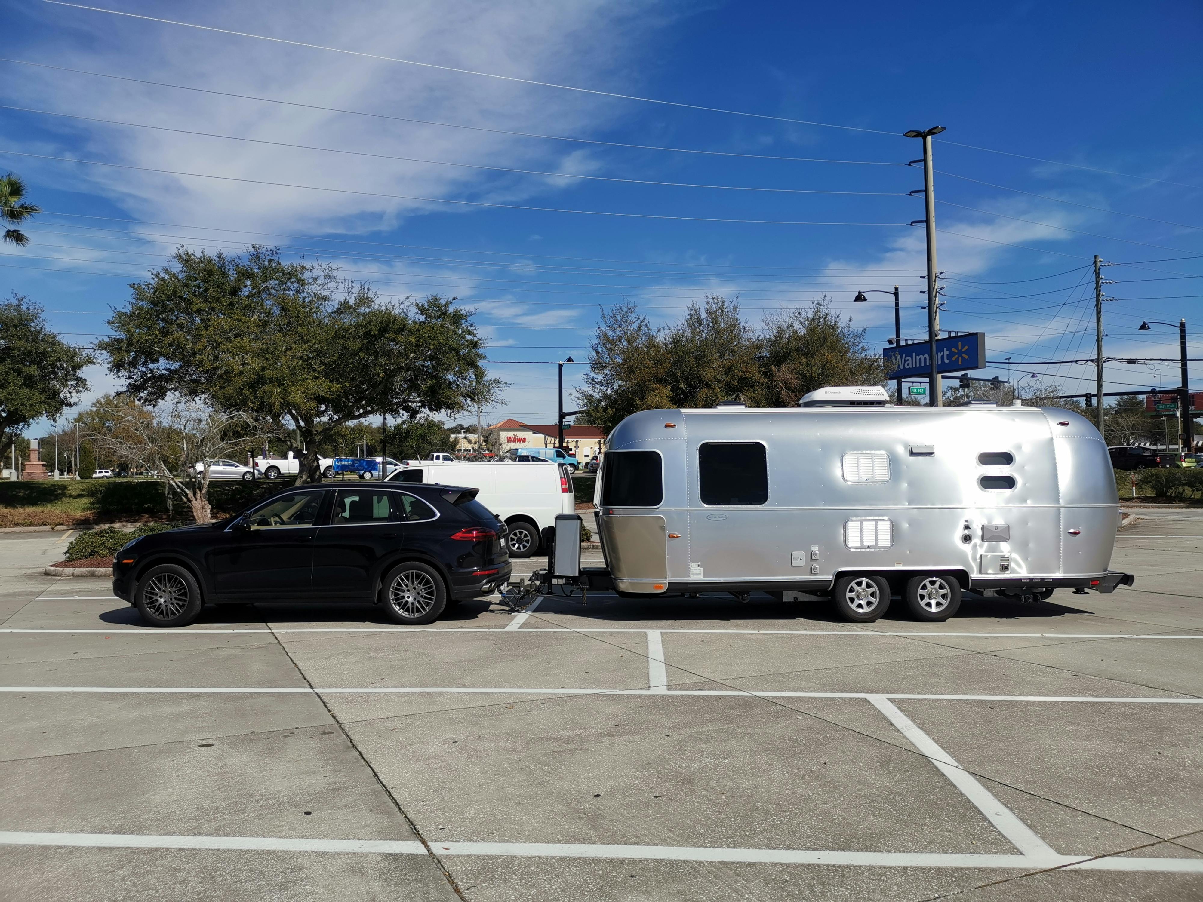 A truck towing an airstream RV parked in a Walmart parking lot