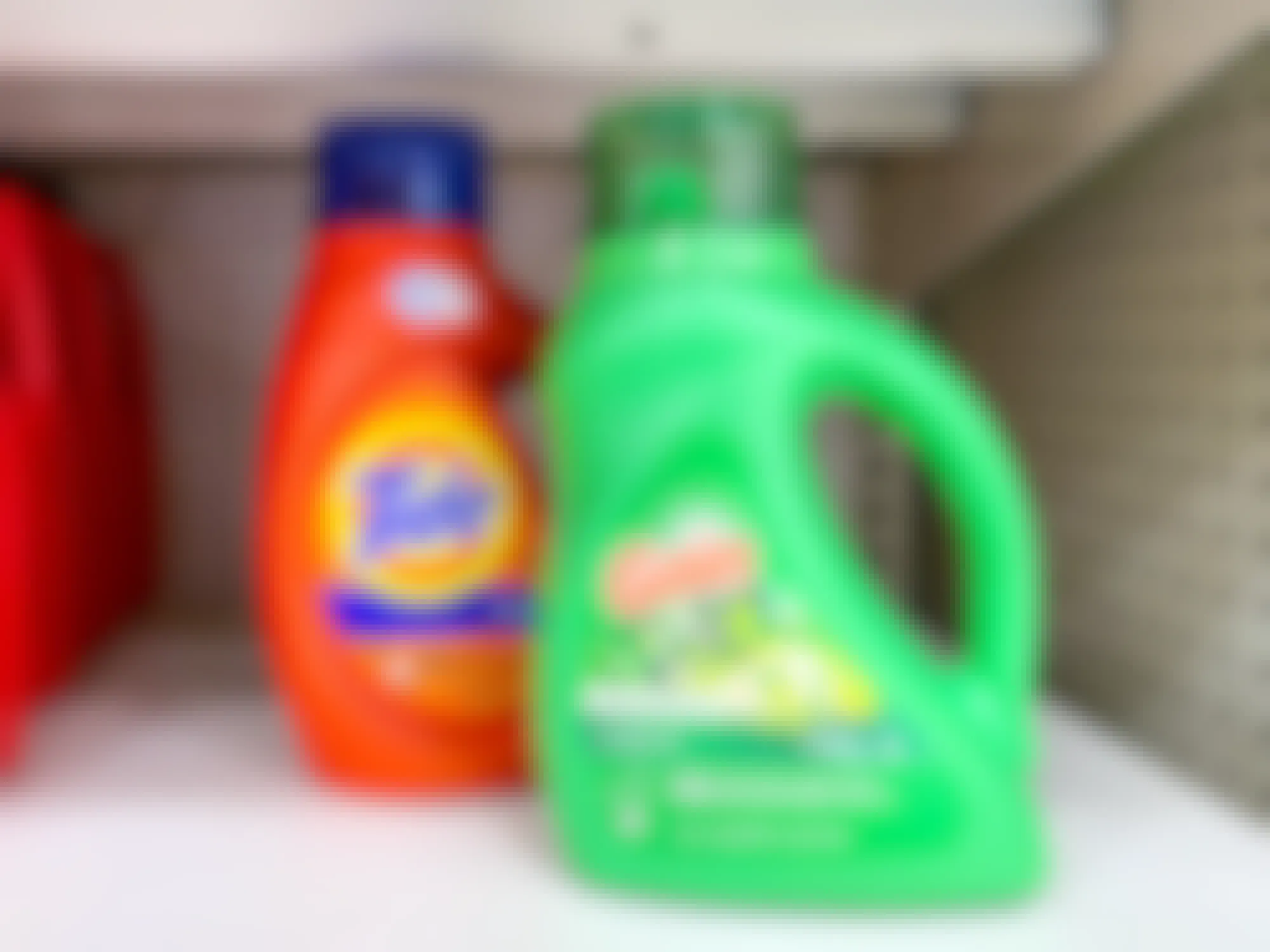 bottles of tide and gain original laundry detergents on store shelf