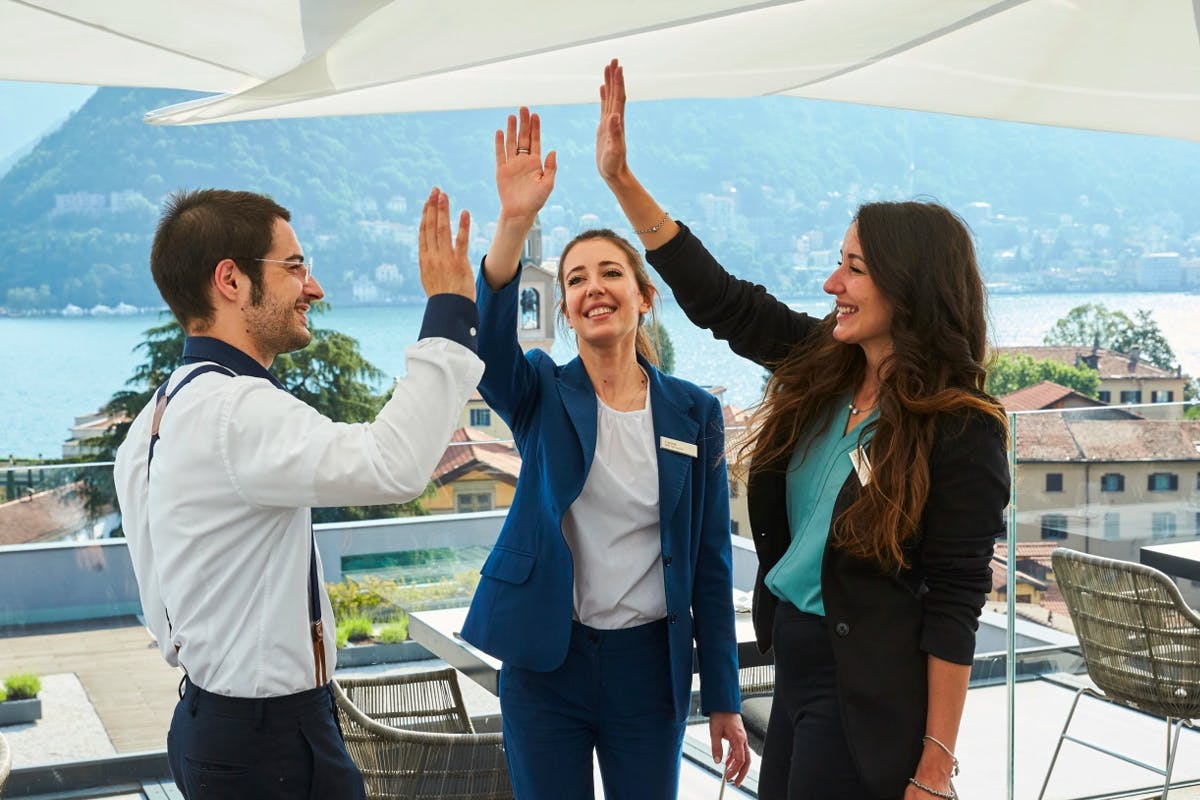 Three Hilton employees come together for a high five