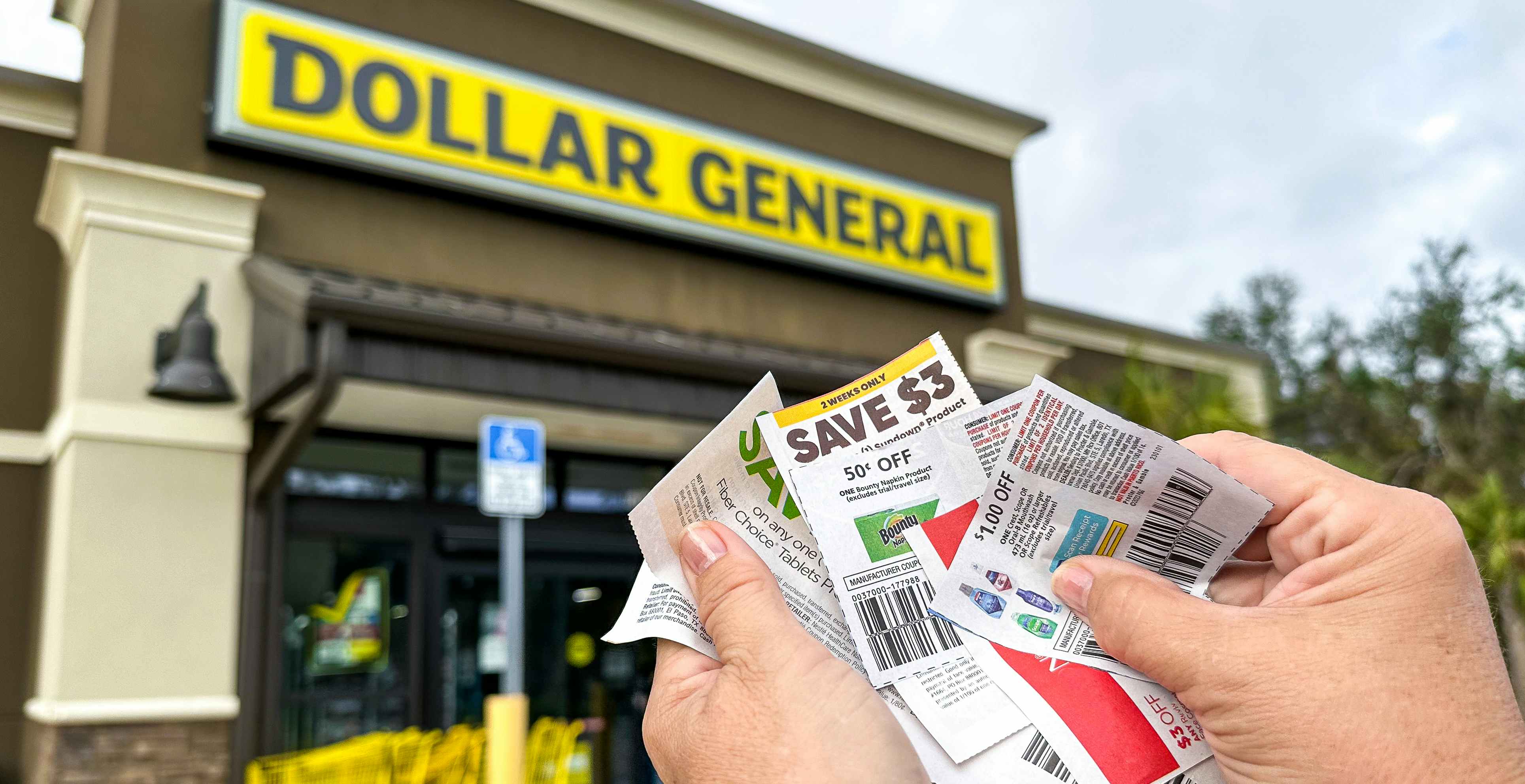 Someone holding coupons outside of a Dollar General