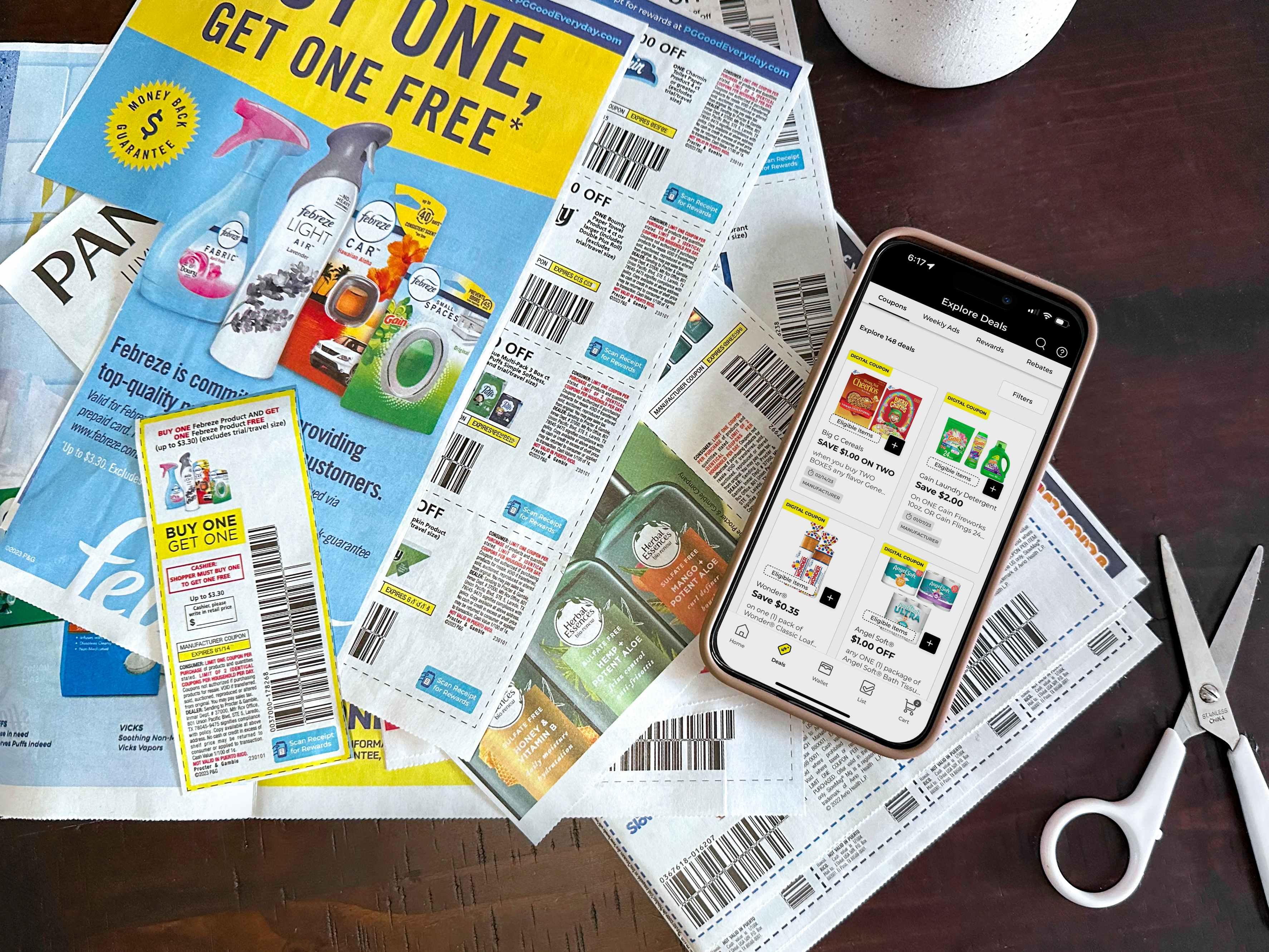 A phone displaying digital coupons in the Dollar General app on a table with some paper manufacturer coupons that have been cut