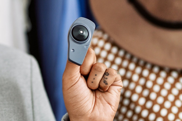 Someone holding up a security tag for clothing