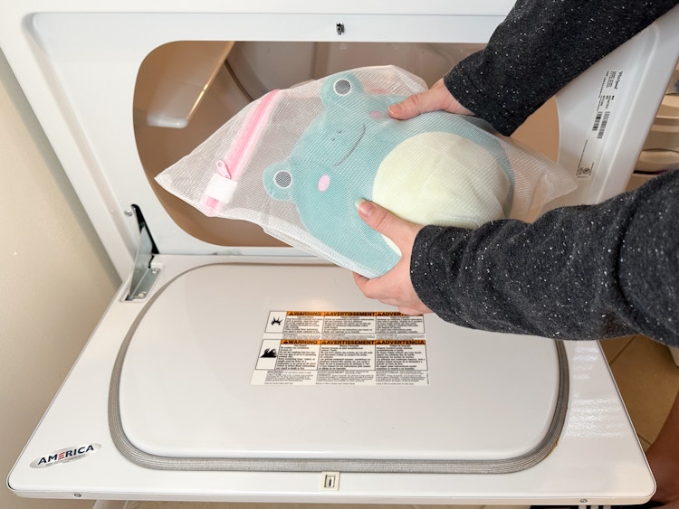 Someone putting a Squishmallow into the dryer 