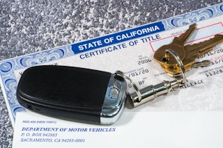 Keys to a vehicle on top of the Certificate of Title from the CA DMV