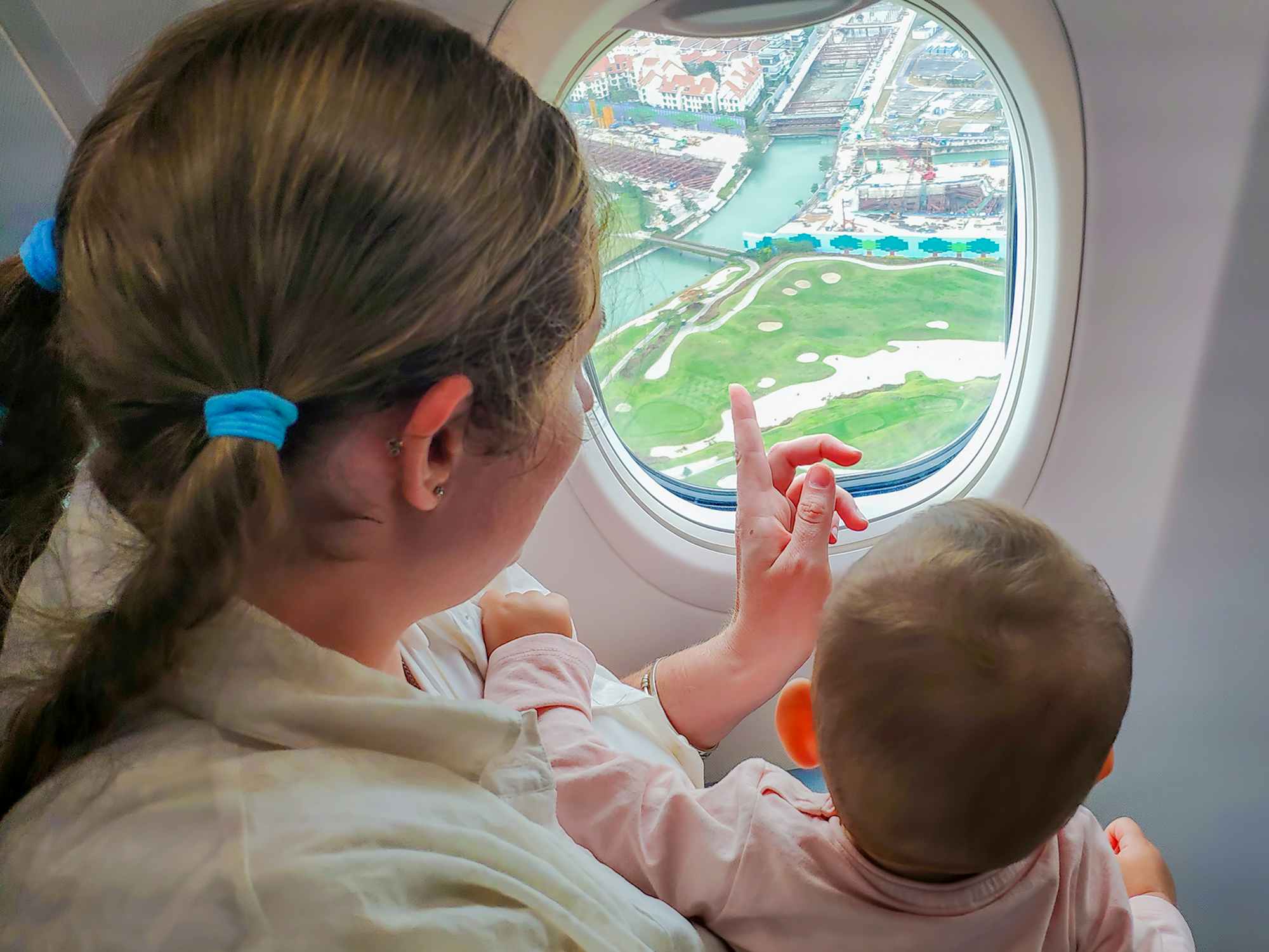 a person and a baby looking out of an airplane window