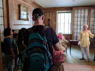 Tour guide leading a group of people through King Manor