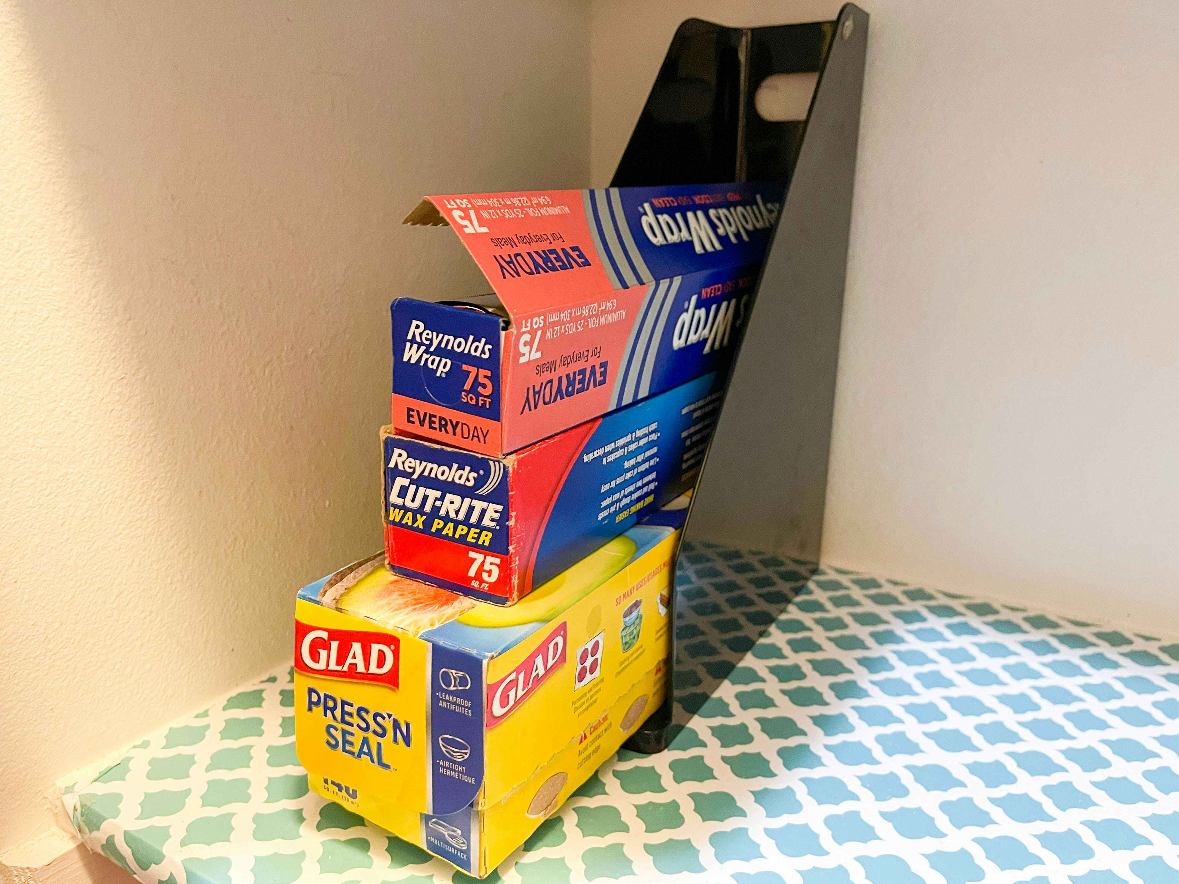 a magazine rack in a pantry with tin foil and wax paper 