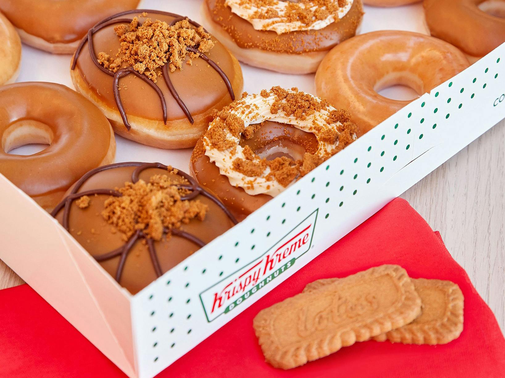 krispy kreme biscoff doughnuts in box near lotus cookies