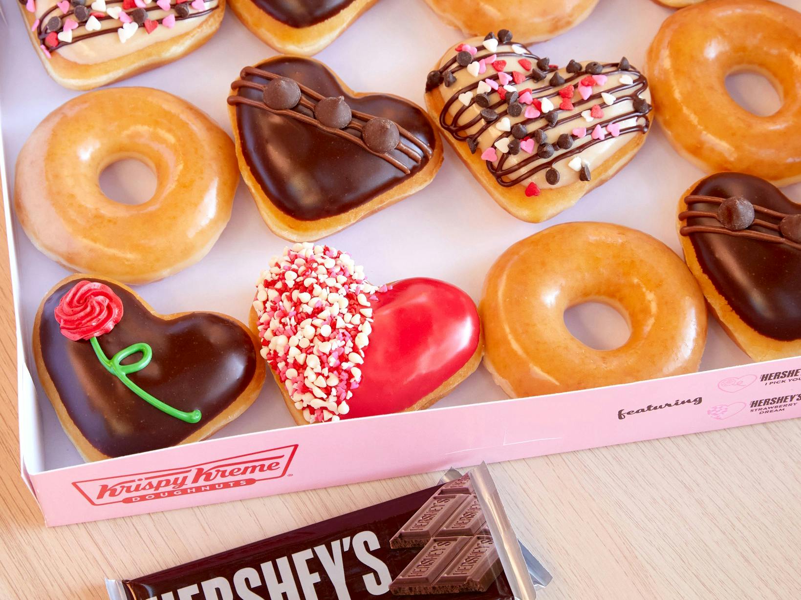 a group of krispy kreme valentines doughnuts in a box