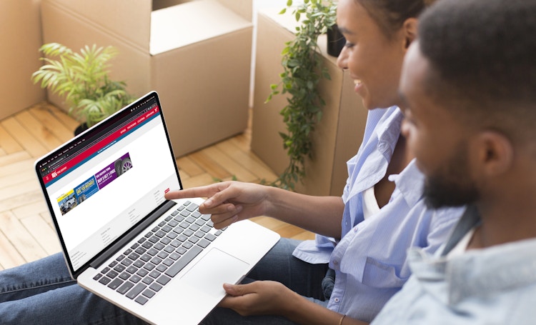 Black Couple sit down and look at computer screen