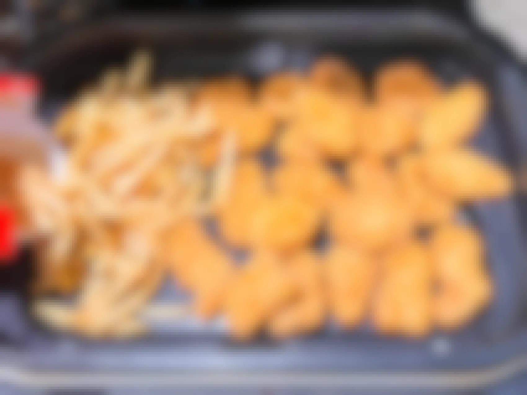 Chicken nuggets and fries inside an air fryer
