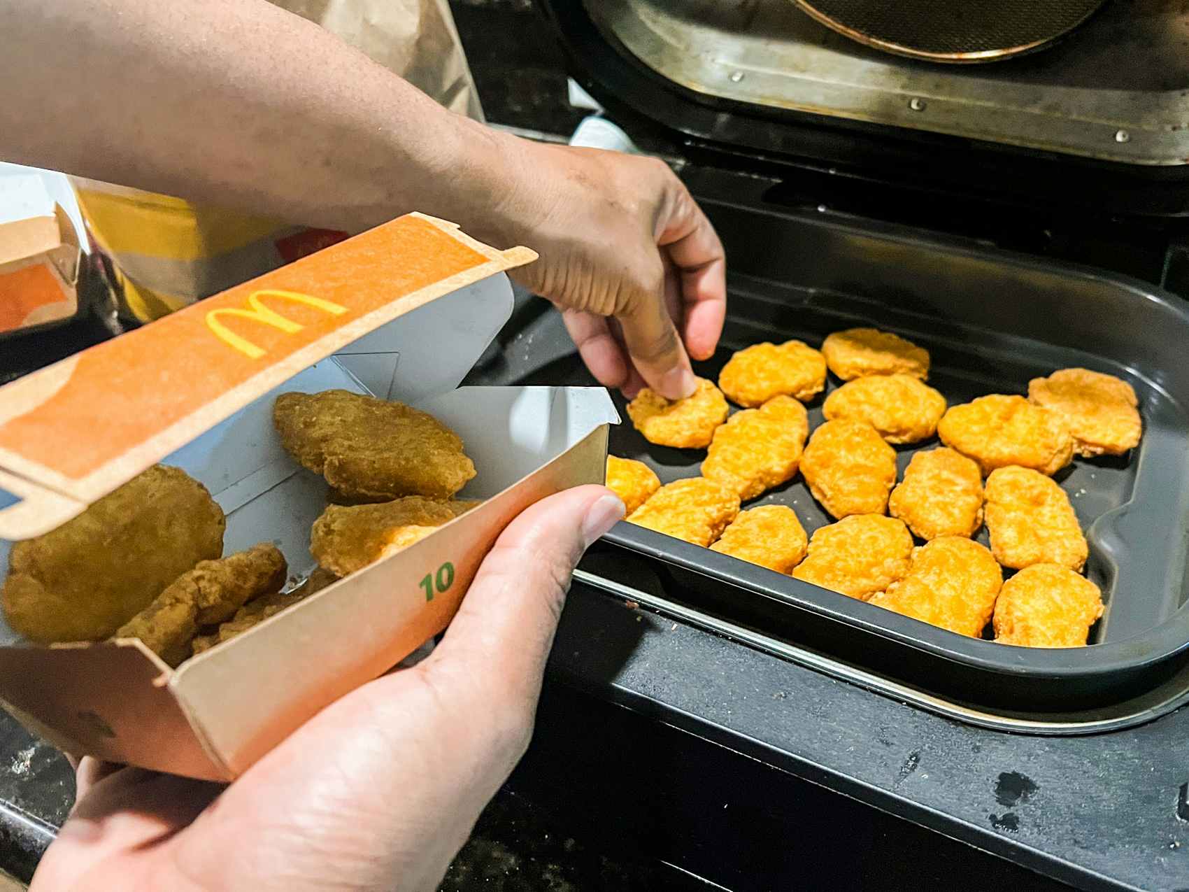Person putting chicken nuggets into an airfryer