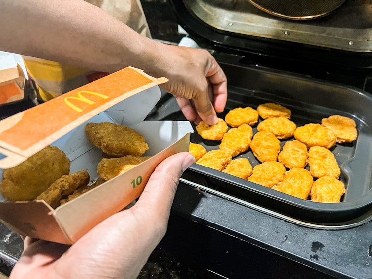 Person putting chicken nuggets into an airfryer