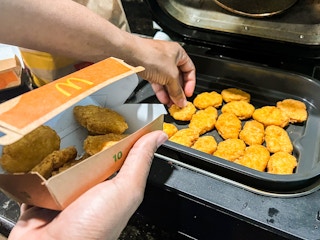 Person putting chicken nuggets into an airfryer
