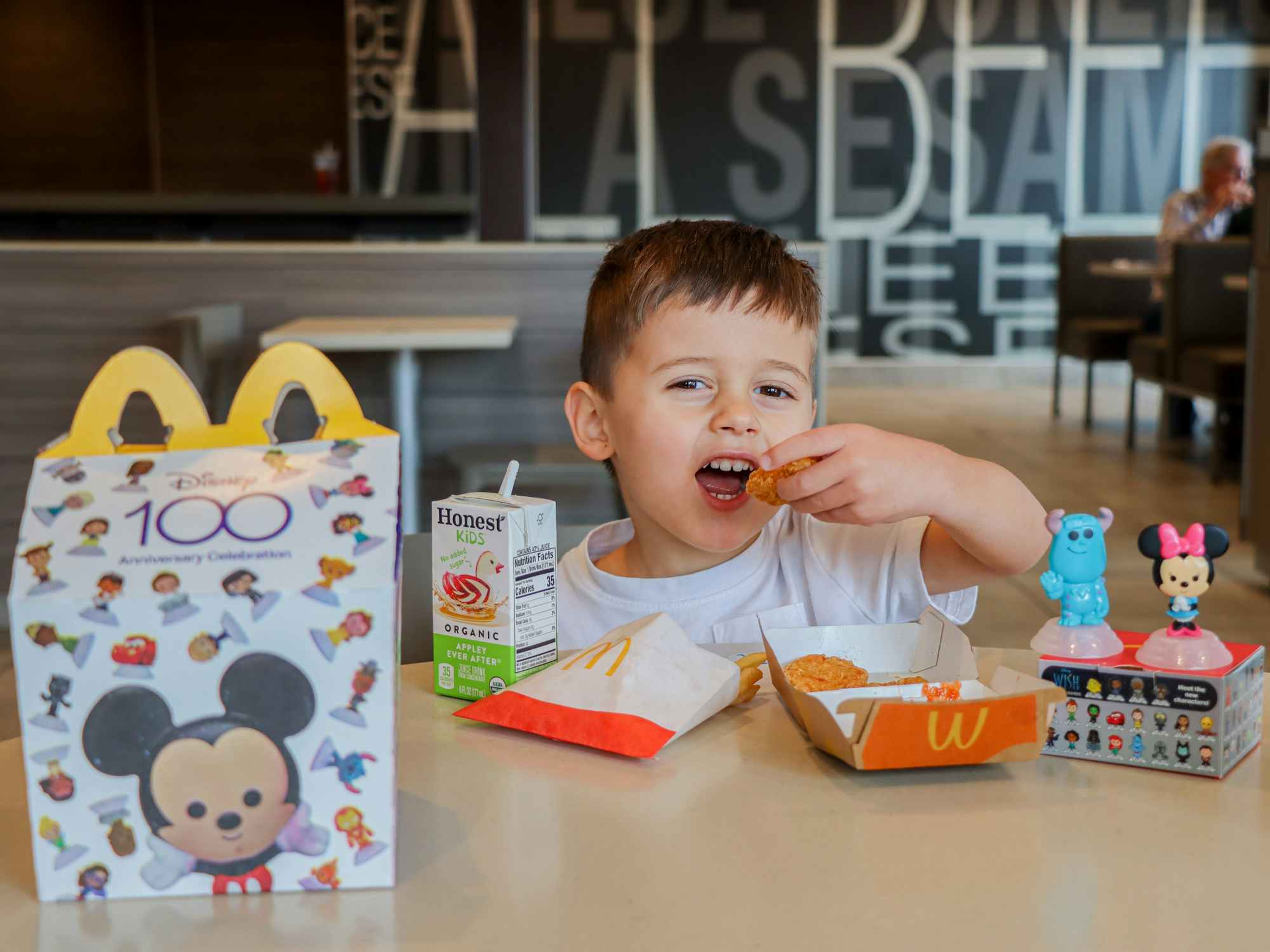 a child taking a bite out of a chicken nugget at mcdonalds