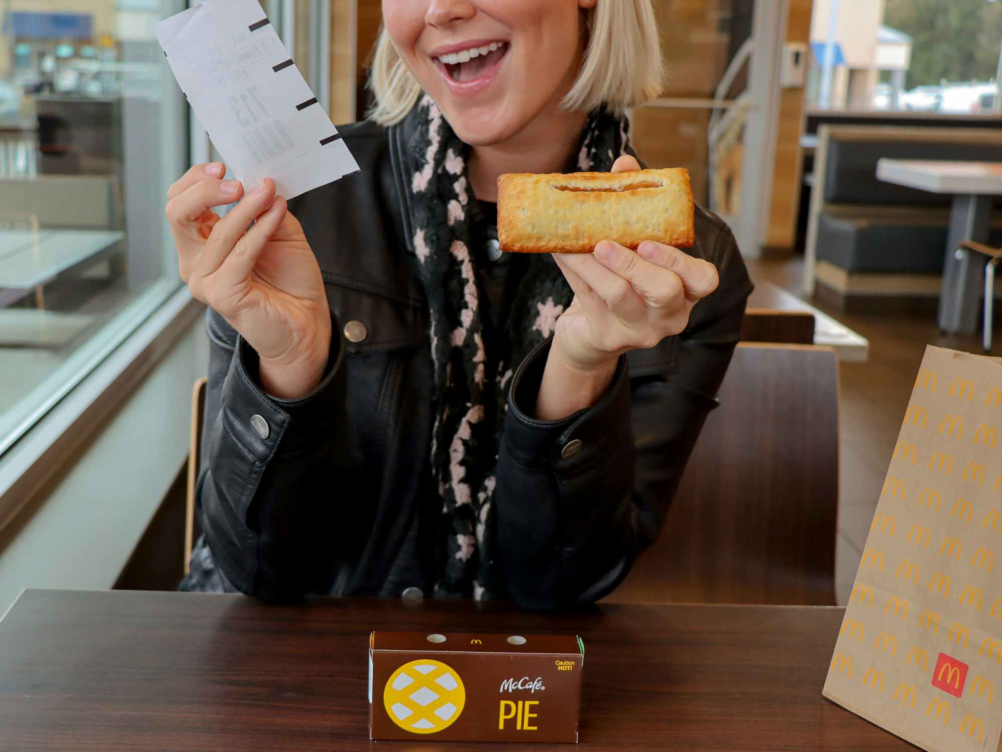 a person holding up a receipt and a mcdonalds pie 