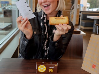 a person holding up a receipt and a mcdonalds pie 