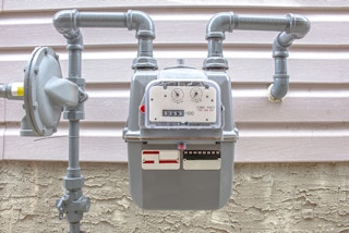 a natural gas meter on the outside of a house