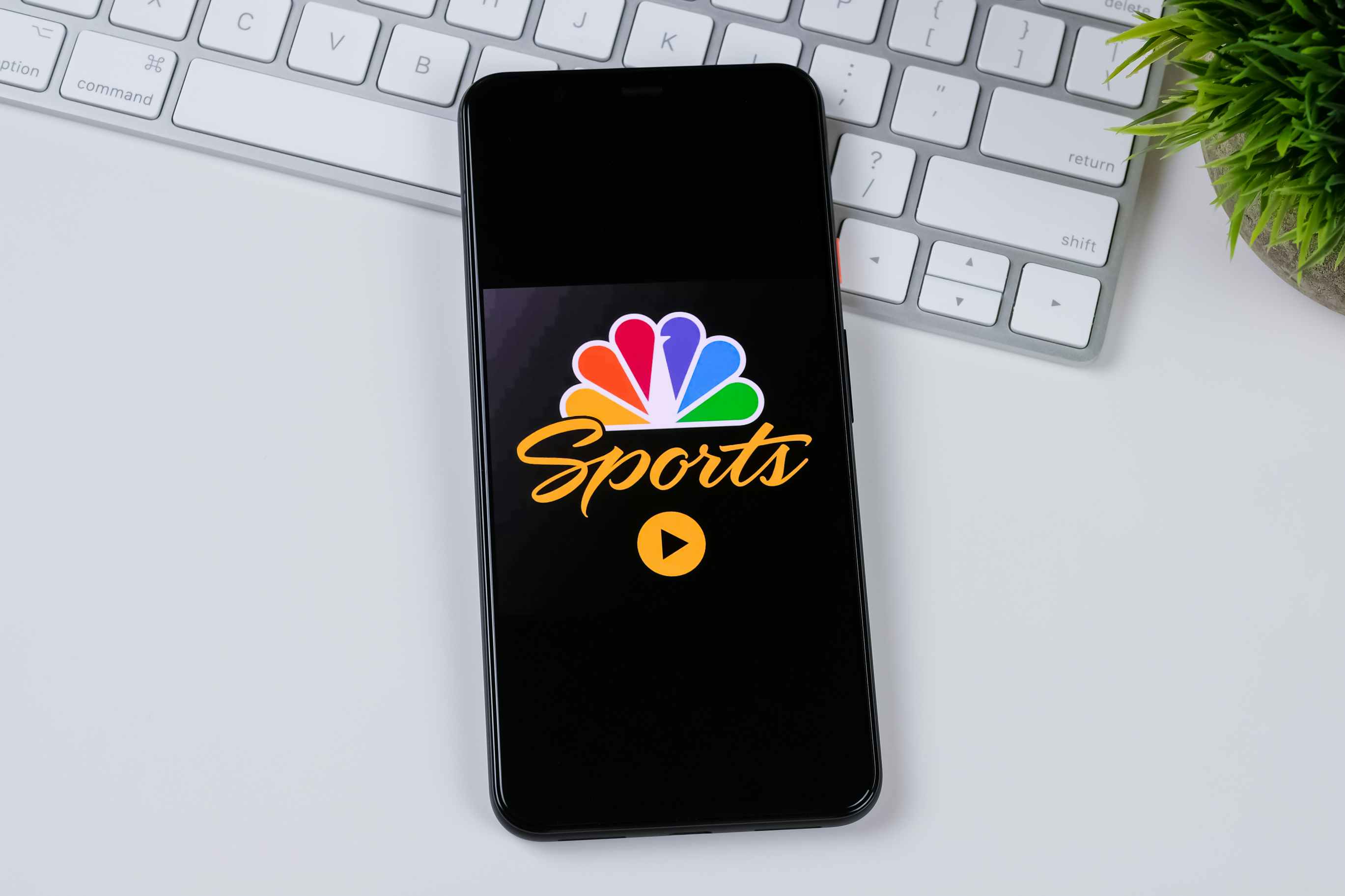 NBC sports on iphone on a computer desk