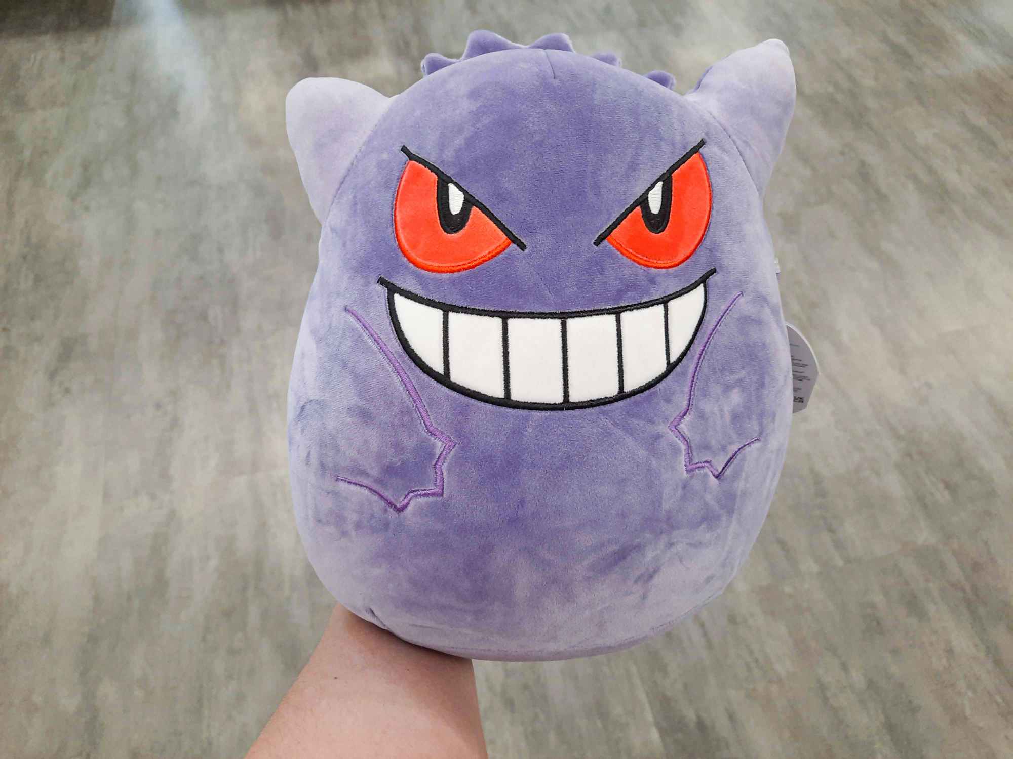 a person holding up a pokemon suishmallow