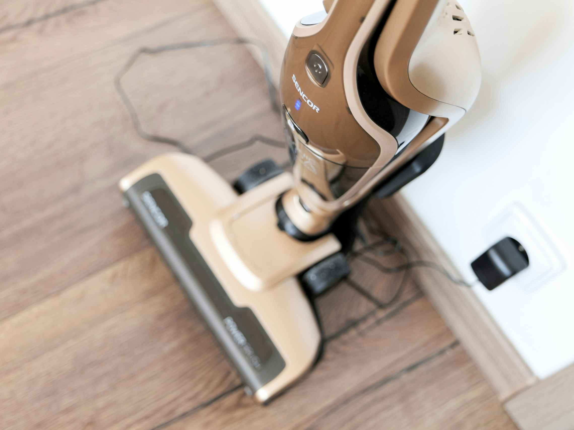 A cordless vacuum plugged into a wall to charge