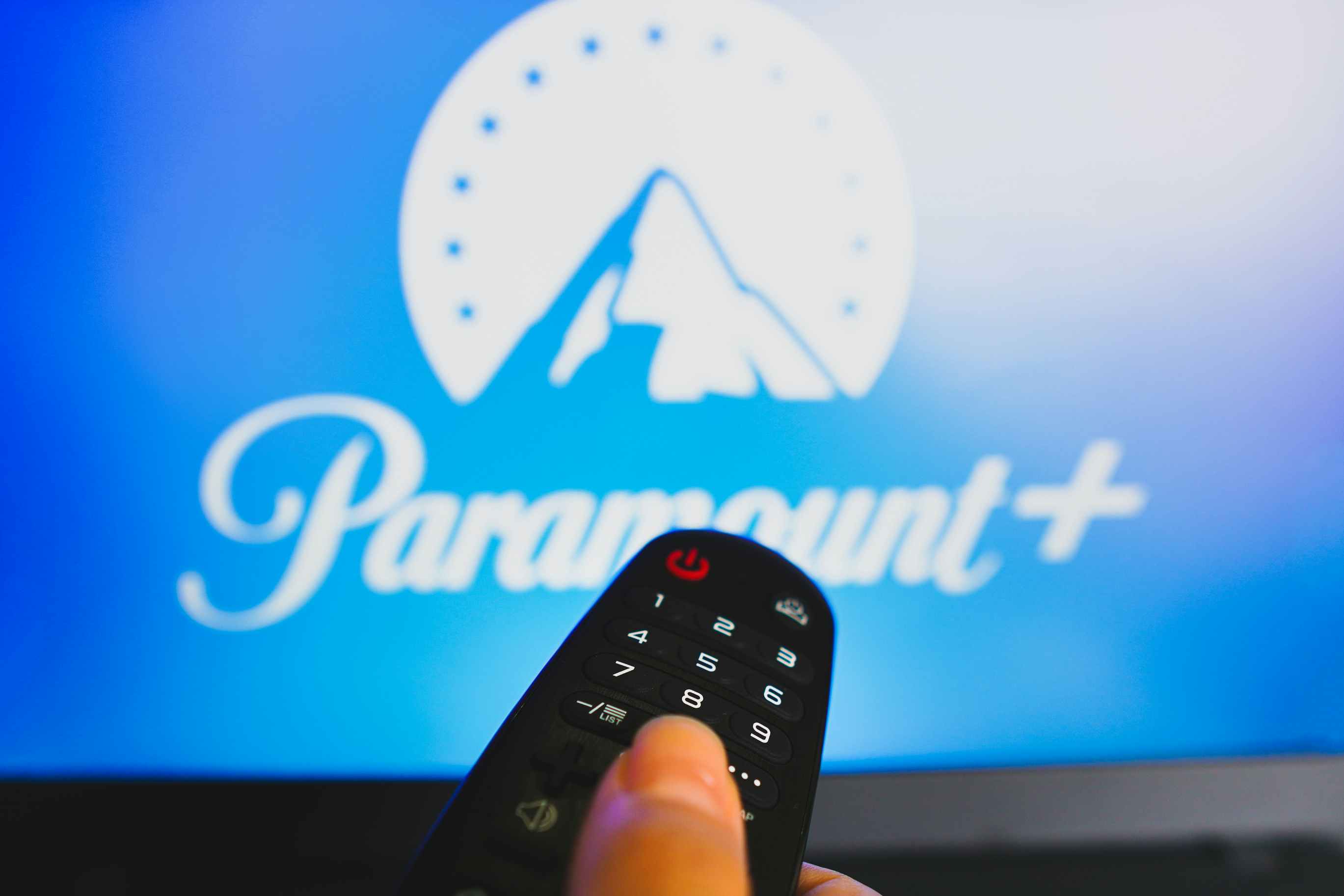 Paramount + logo screen on tv while someone presses a tv remote