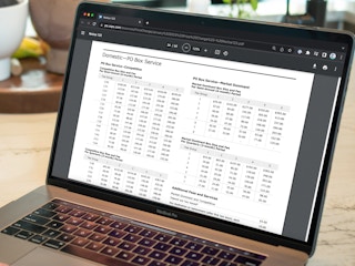 A laptop displaying the USPS Notice 123 page for the Domestic PO Box Pricing for 2023