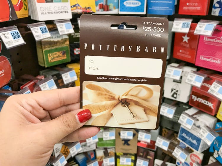 A woman's hand holding a Pottery Barn gift card for $0 to $500