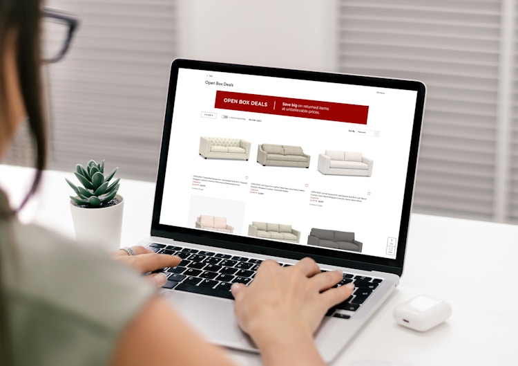 A woman on her laptop looking at discounted Open Box items on PotteryBarn.com