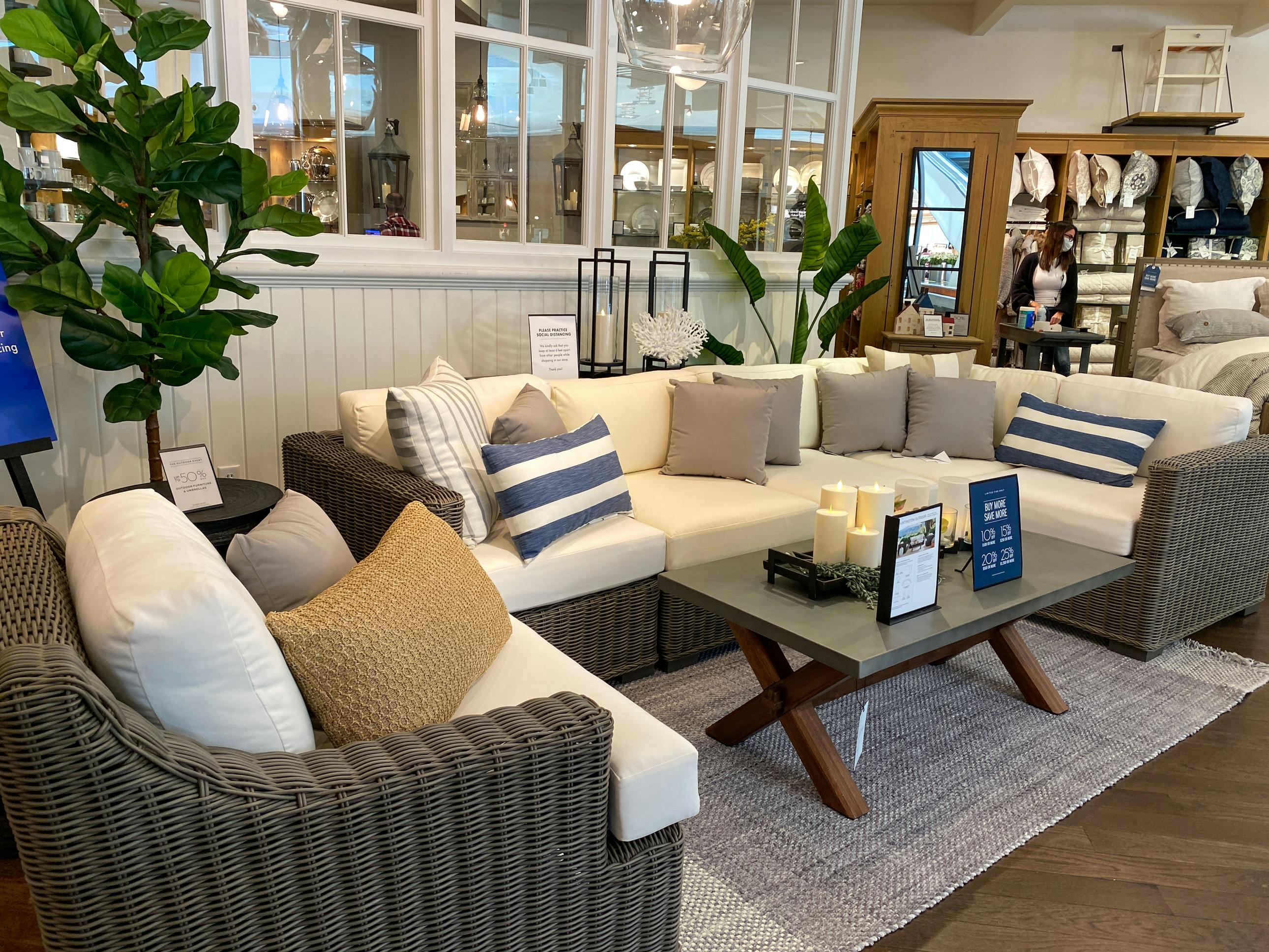 a display of wicker outdoor furniture at a pottery barn outlet store