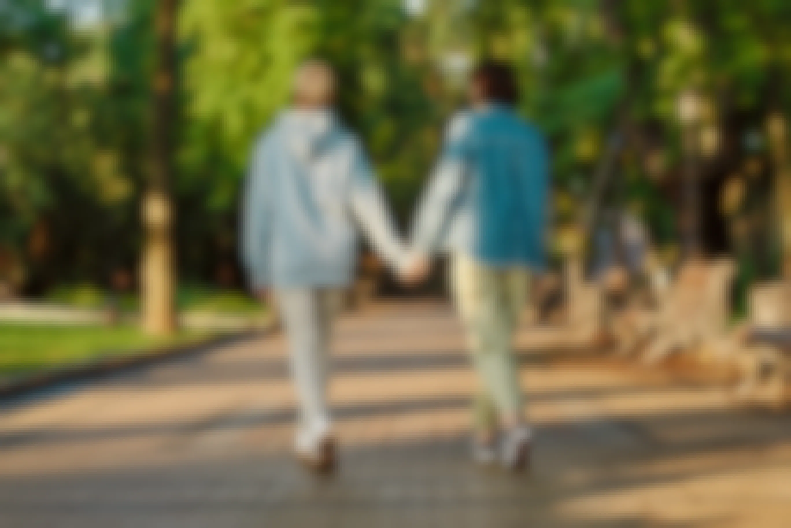 Two people holding hands and taking a walk in a park