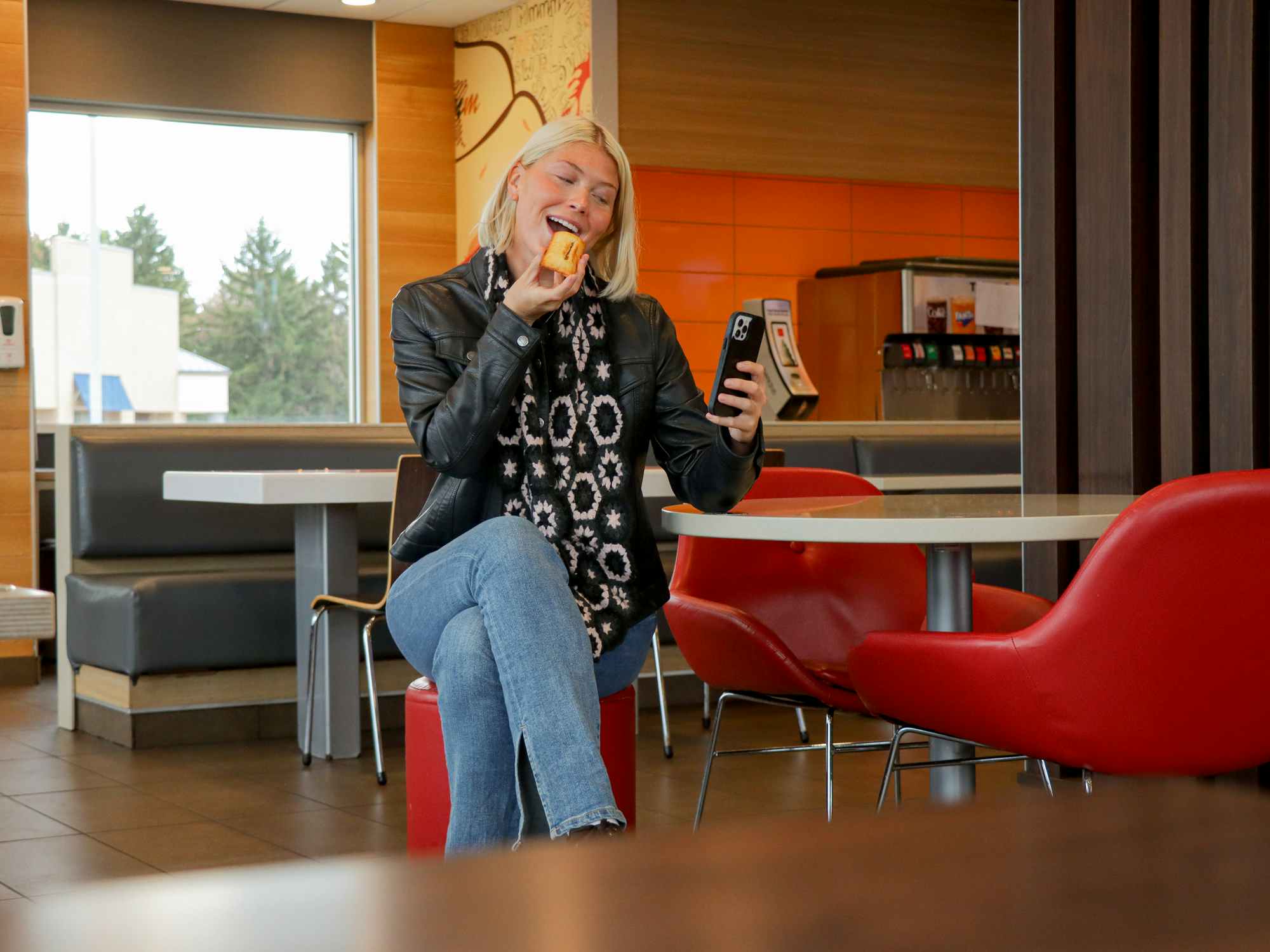 a person on their phone while taking a bite of mcdonalds pie