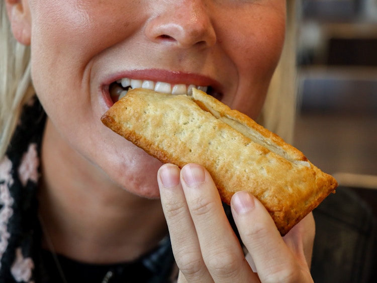 a person taking a bite of a pumpkin pie