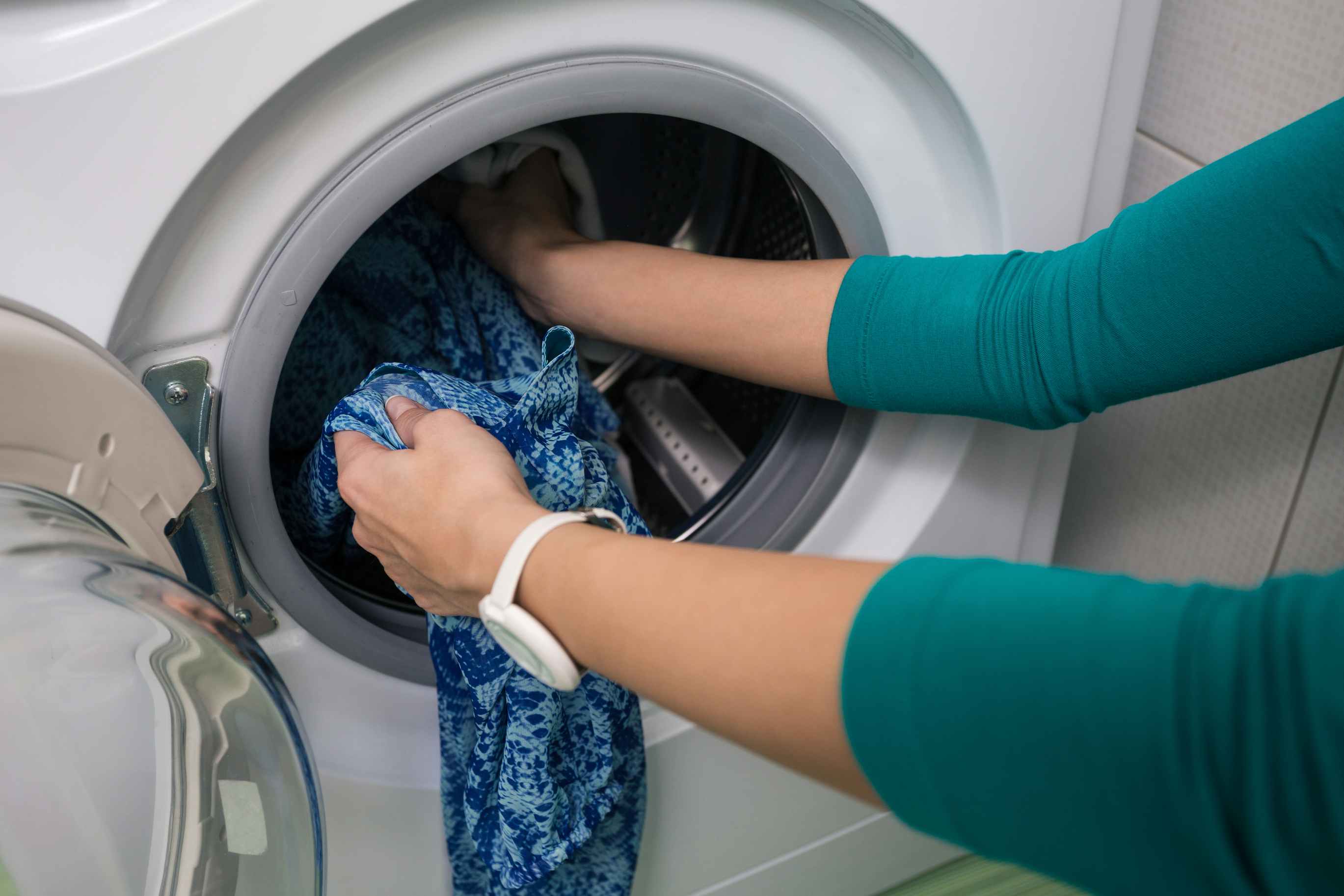 Putting clothes into washing machine