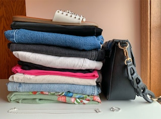 Clothes shoes and purse in a pile