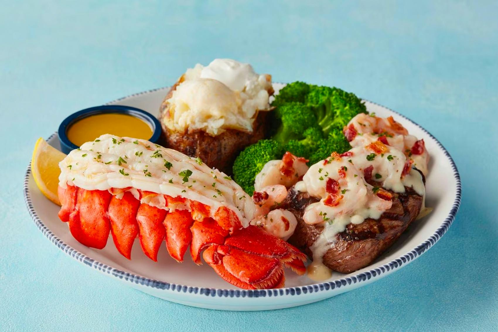 Plate from Red lobster that includes lobster broccoli, baked potato and shrimp topped steak