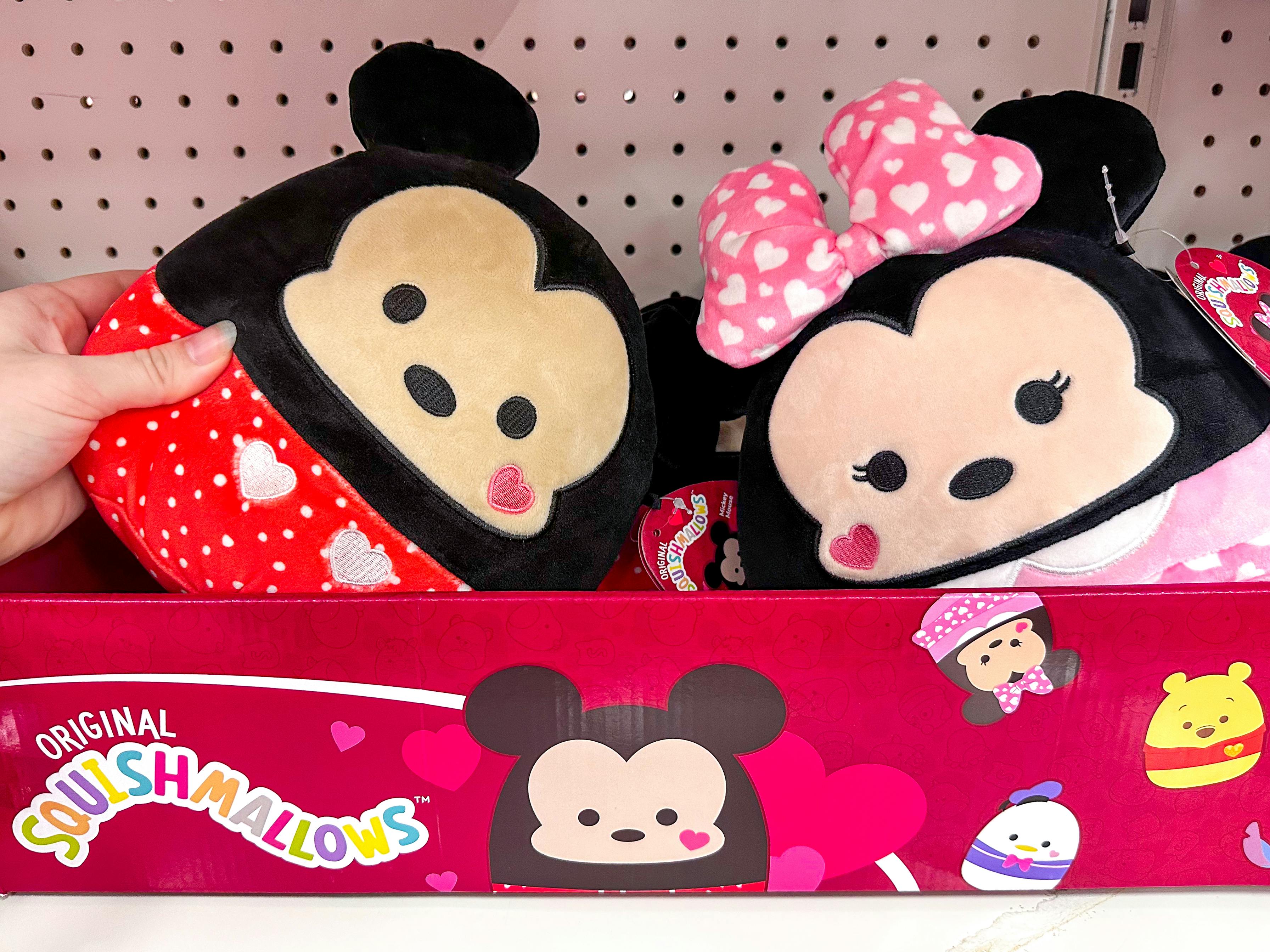 Someone taking a Valentine's Day Mickey Mouse disney Squishmallow out of a box on a shelf at Target