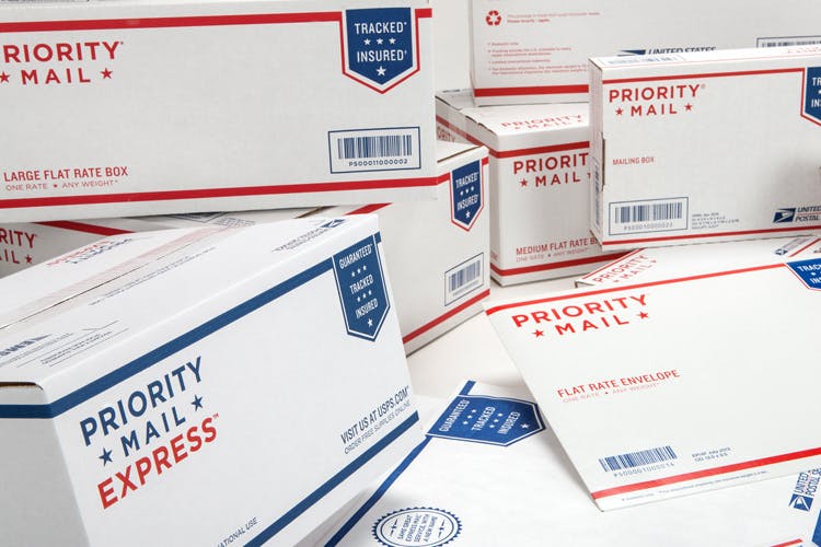 Many USPS Priority Mail packages piled together