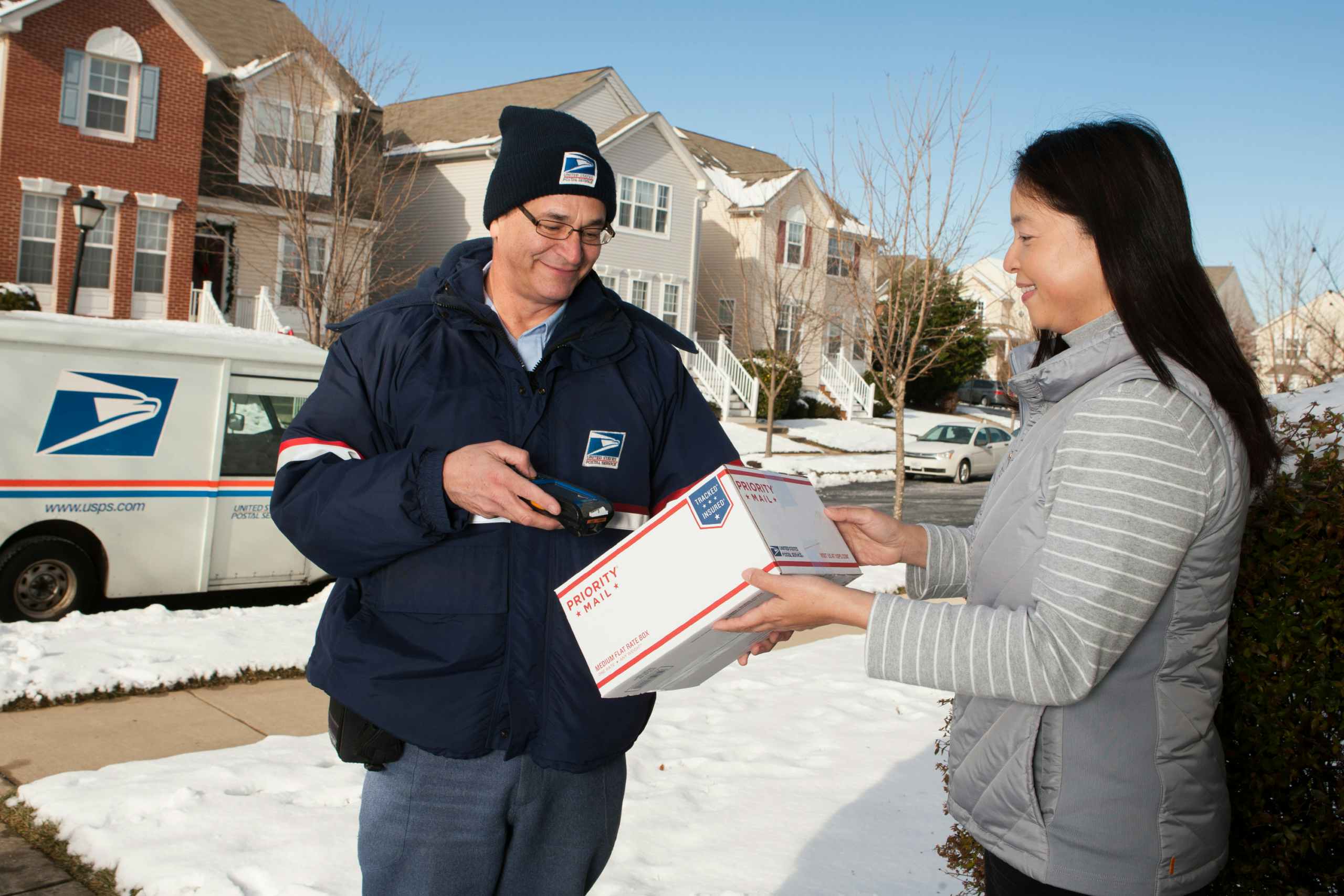 A USPS Driver delivering a package to a person at their house