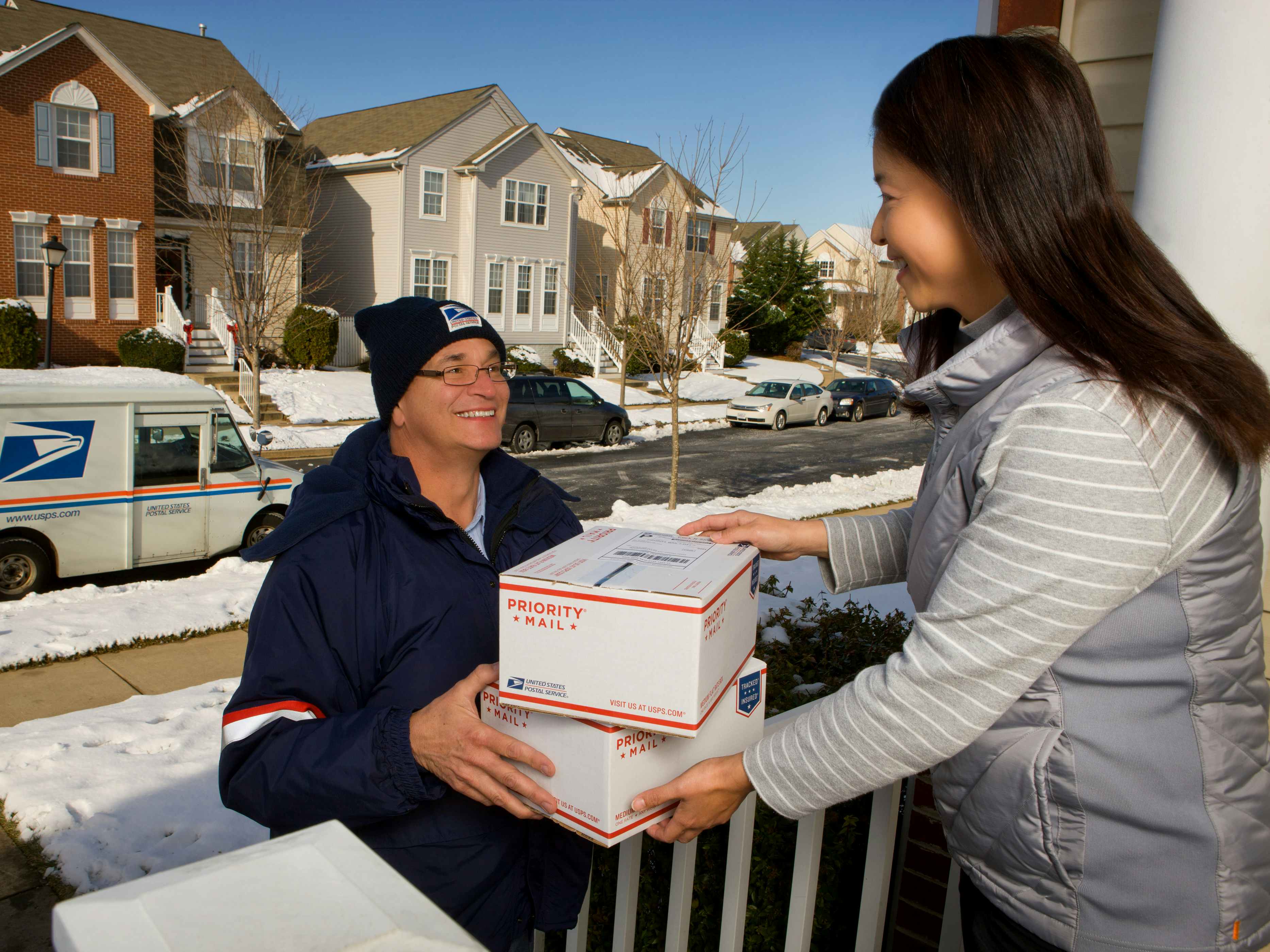 A USPS Driver delivering packages to a person at their house