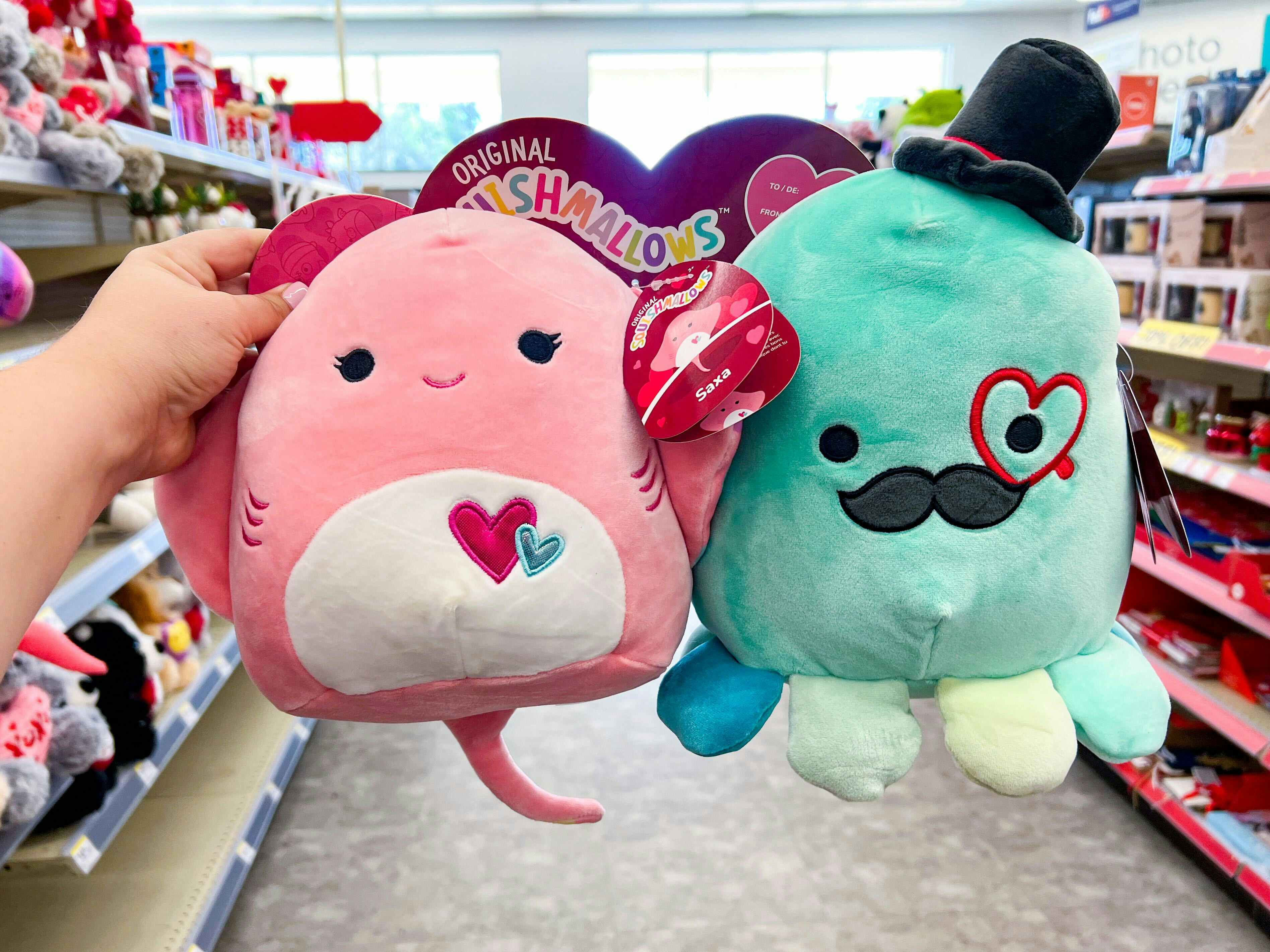 Someone holding up a Valentine's Day set of Squishmallows in Walgreens