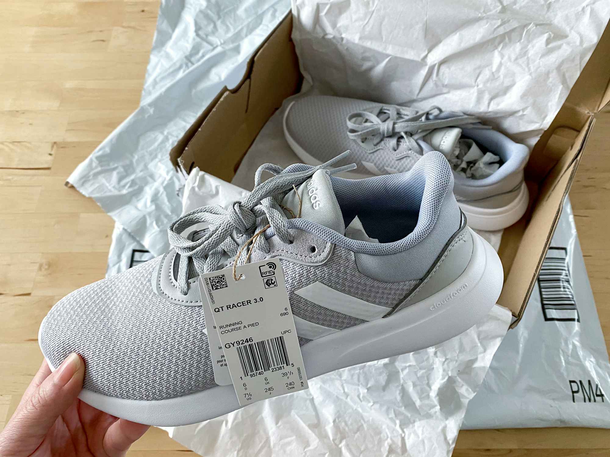 person holding new adidas sneaker