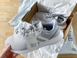 person holding new adidas sneaker
