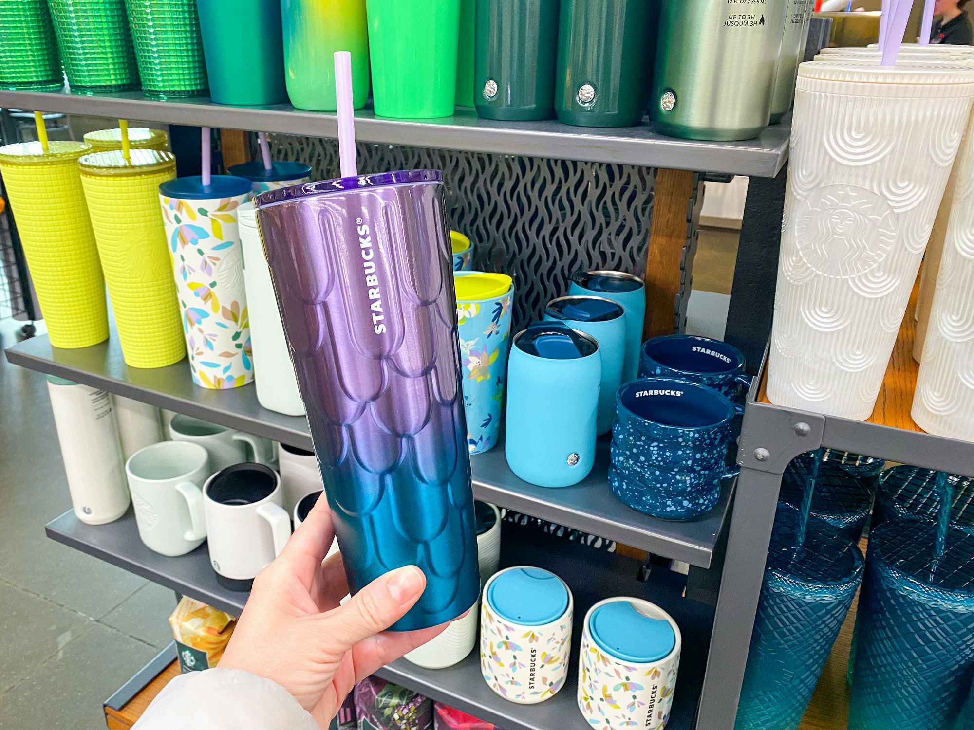 hand holding starbucks spring 2023 spring blue and purple mermaid scales stainless cold cup tumbler