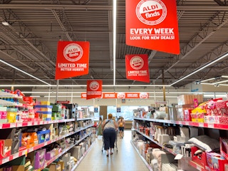 Someone walking down the ALDI finds aisle with a shopping cart