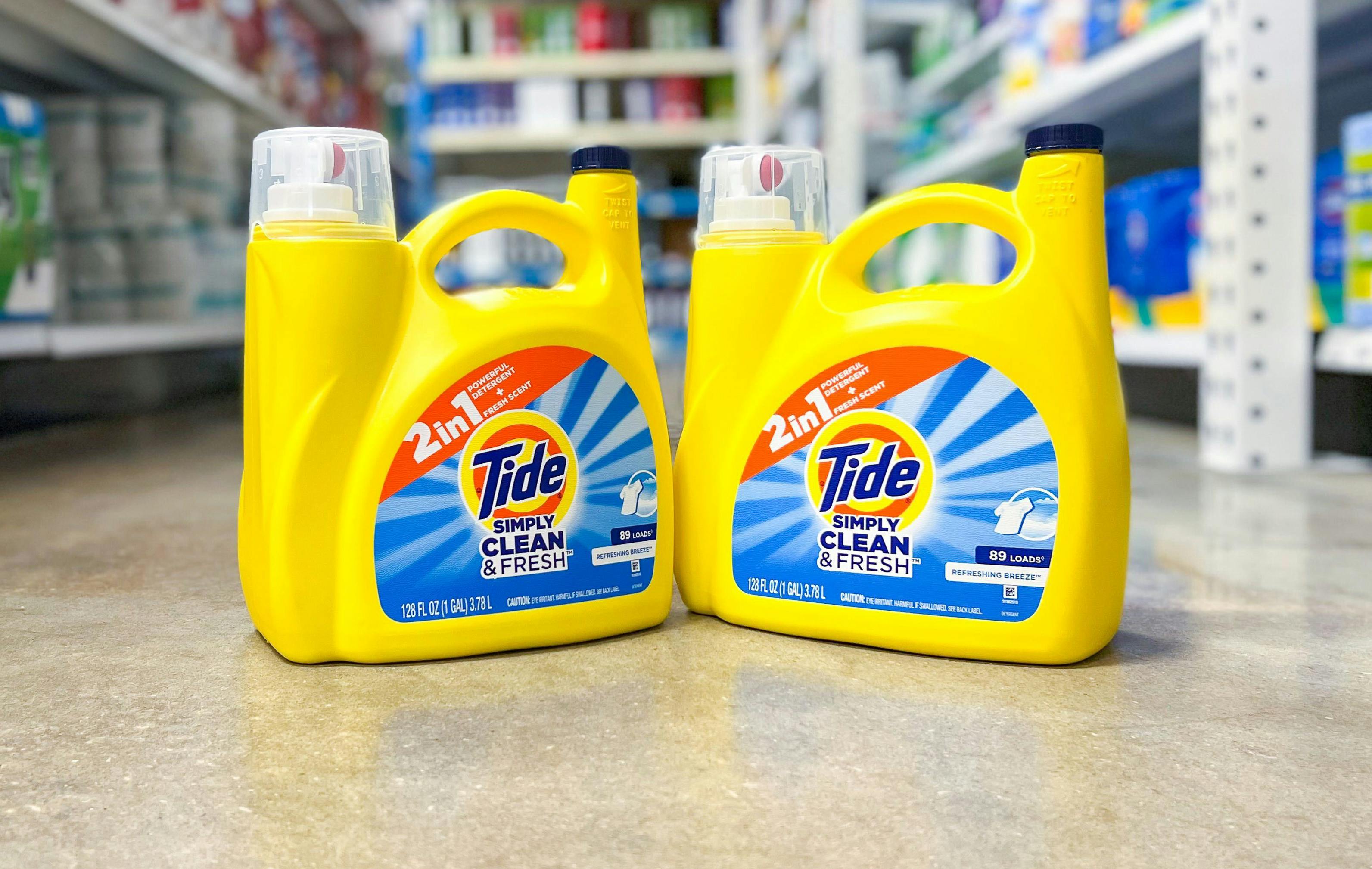 two large bottles of tide simply laundry detergent on a floor in a store